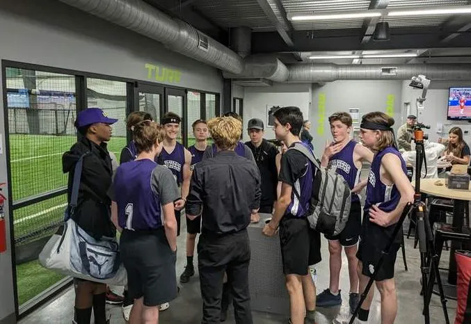 Panthers basketball players huddled with their coach
